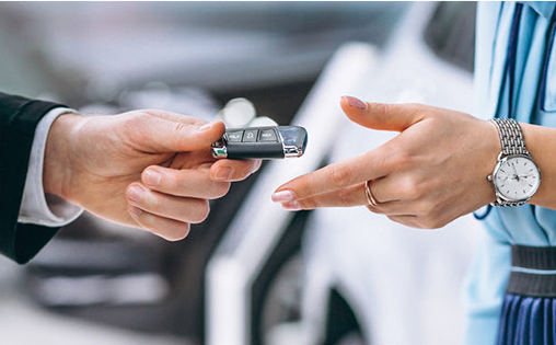 Customer receiving car keys from dealership representative during vehicle purchase