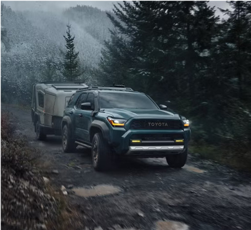 Toyota 4Runner towing trailer on rugged forest trail