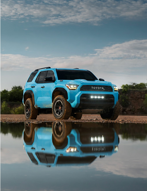 blue Toyota 4Runner parked near water with reflection on surface