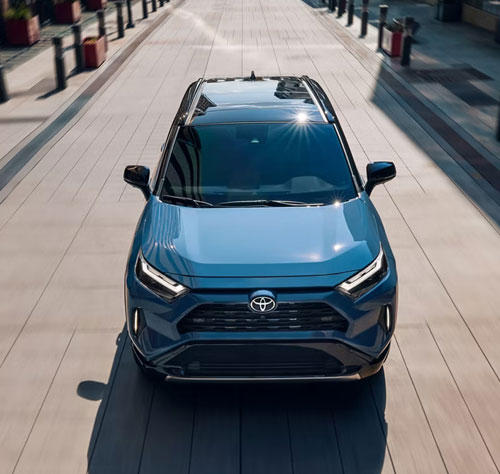 Top view of a blue Toyota RAV4 driving through an open plaza
