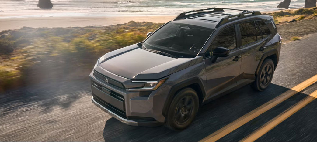 Toyota SUV driving along a coastal road with ocean scenery