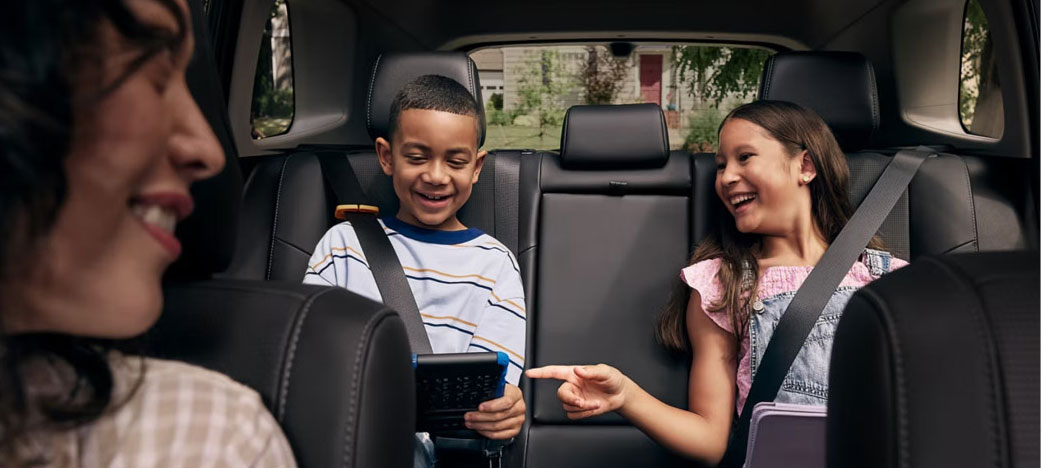 Family riding in the back seat of a Toyota RAV4 during a road trip