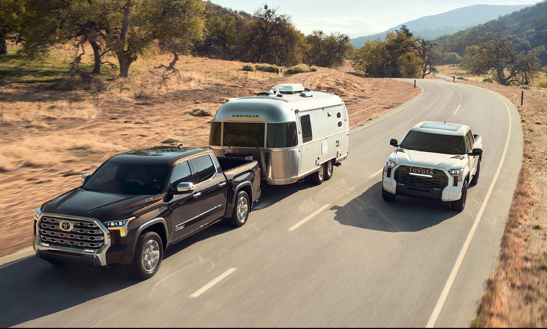 Toyota Tundra towing an Airstream trailer with a Toyota Tacoma pickup driving alongside