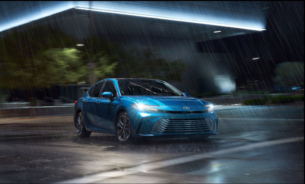 Toyota Corolla sedan driving in the rain with headlights on