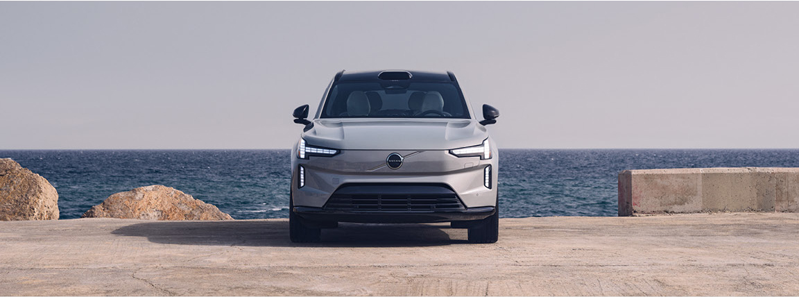 Front view of Volvo electric SUV parked by the ocean with minimalist design