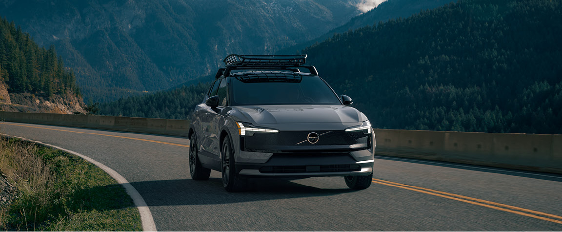 Volvo EX30 driving through a mountain landscape, showcasing electric SUV performance, Scandinavian design, and adventure-ready capability