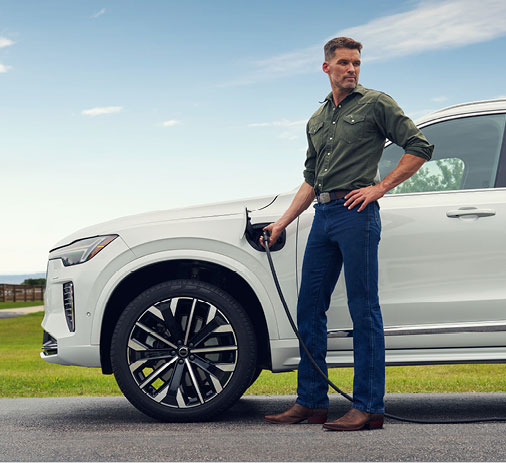 A man charging a Volvo vehicle