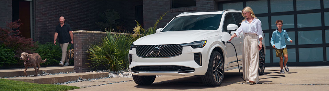 A Woman charging a Volvo vehicle