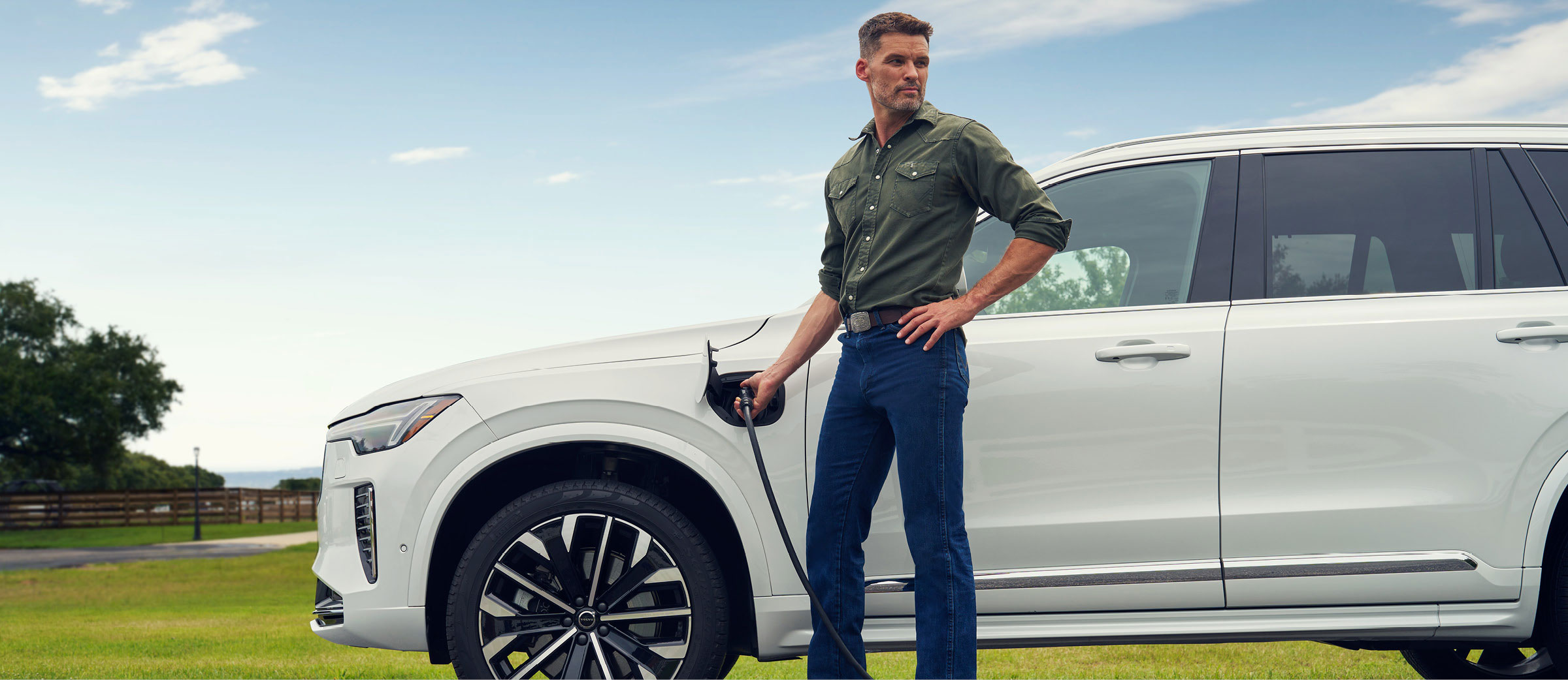 A man charging a Volvo electric SUV outdoors