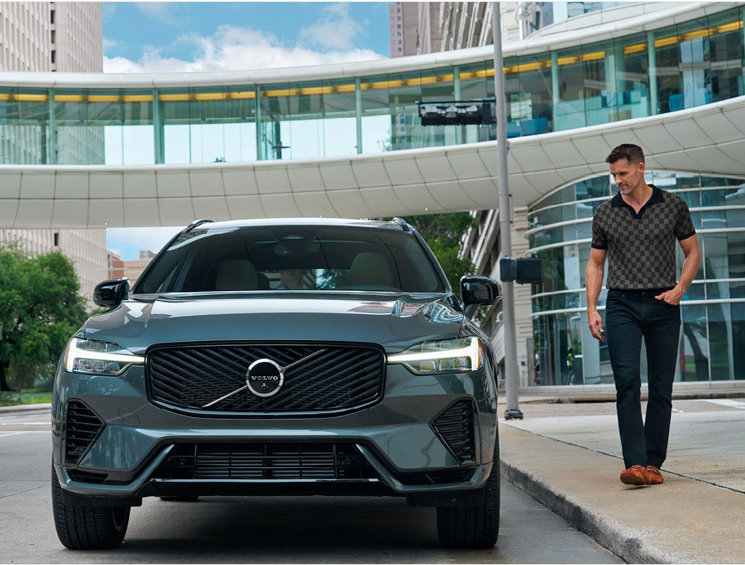 Volvo SUV parked in an urban setting with driver walking nearby