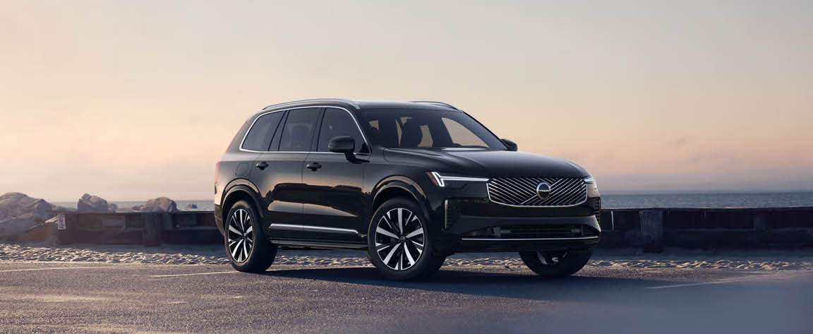 Volvo XC90 luxury SUV parked along a scenic coastal road at sunset