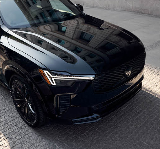 Front design and LED headlights of a Volvo XC90 luxury SUV in an urban setting