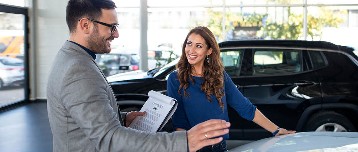 Volkswagen sales consultant discussing financing options with customer in showroom