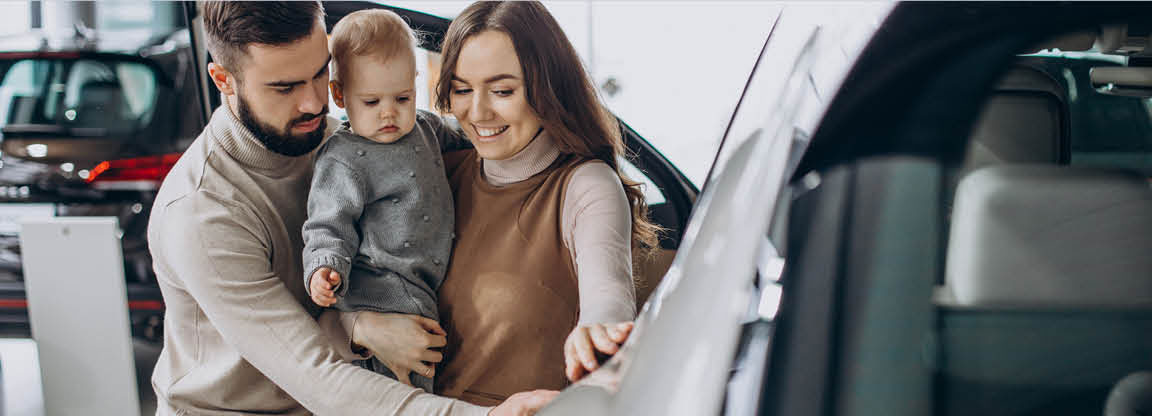 Family with child exploring vehicle interior at Volkswagen dealership showroom