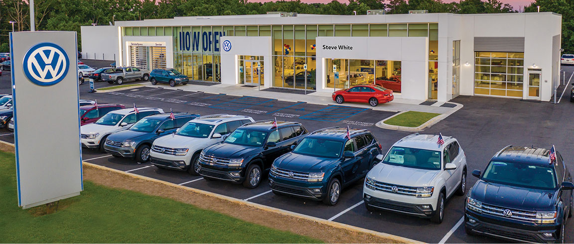 Volkswagen dealership exterior with new SUV inventory parked in front