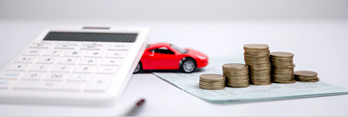 auto financing concept with calculator toy car and stacked coins