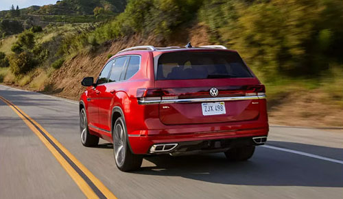 red Volkswagen Atlas SUV driving on highway from rear view in scenic landscape