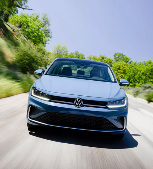 Volkswagen Jetta driving on a scenic road demonstrating confident handling, efficiency, and smooth everyday performance