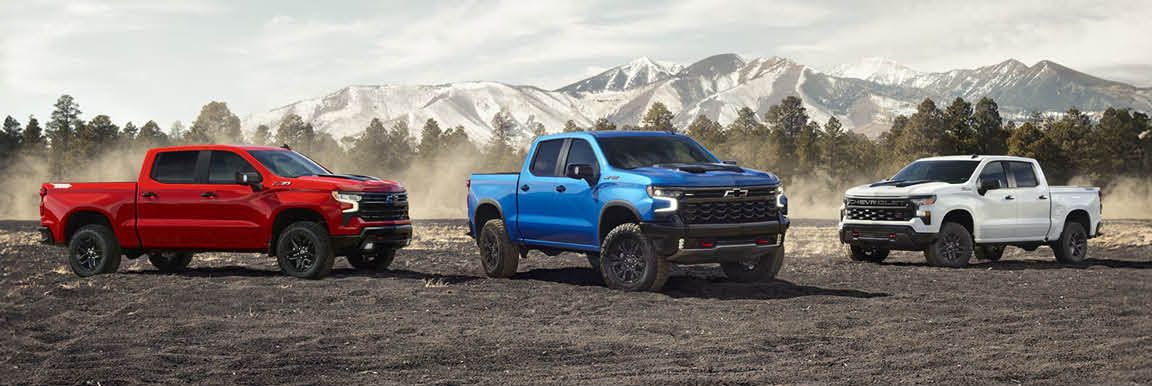 Chevrolet Silverado truck lineup parked in an off-road landscape