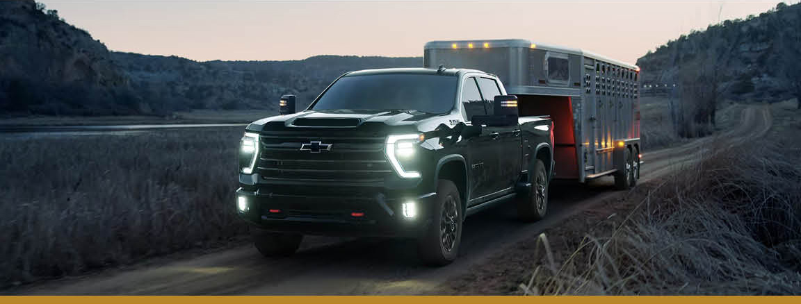Chevrolet Silverado HD truck towing a horse trailer at night