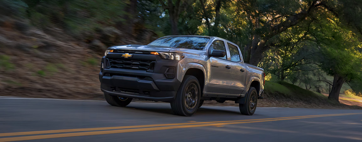 Chevrolet Silverado pickup truck driving on a scenic forest road