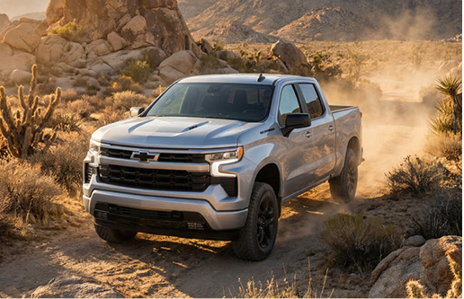 silver Chevrolet Silverado pickup truck navigating a rugged desert trail