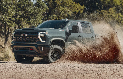 Chevrolet Silverado HD ZR2 pickup truck driving through mud and gravel terrain